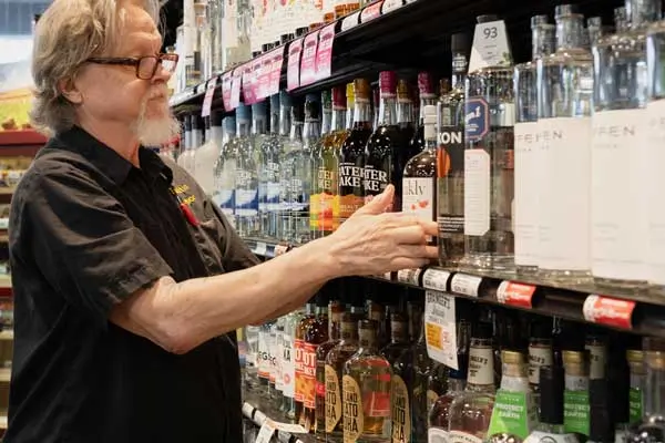 Distilled-1-600x400-1 Team member stocking bottles onto a shelf